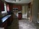 Open kitchen with dark cabinets, stone tile backsplash, stainless microwave, and tile flooring at 6733 Jojanne Ln, Lithonia, GA 30038