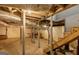 Unfinished basement featuring exposed piping, support beams, a staircase, and concrete flooring at 627 S Elizabeth Nw Pl, Atlanta, GA 30318
