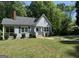 Charming one-story home with light-blue siding, brick chimney and covered porch surrounded by lush greenery at 627 S Elizabeth Nw Pl, Atlanta, GA 30318