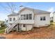 Exterior back of home featuring deck with staircase, sunroom, and white siding at 364 Valleyside Dr, Dallas, GA 30157