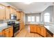 Bright kitchen features wood cabinetry, granite countertops, and stainless steel appliances at 364 Valleyside Dr, Dallas, GA 30157