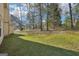 A wide shot shows the backyard with mature trees, grass, and a partial view of the house at 3396 Framingham Dr, Lithonia, GA 30038