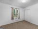 This carpeted bedroom features a window with curtains and a closet with sliding doors at 1001 Stagecoach Rd, Stockbridge, GA 30281
