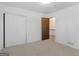 Bedroom with neutral carpet, white walls, double door closet, and wood door entryway at 1001 Stagecoach Rd, Stockbridge, GA 30281