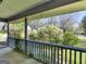 Inviting covered porch overlooking a lush garden with mature trees and greenery at 1001 Stagecoach Rd, Stockbridge, GA 30281