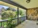 Covered porch with stone wall, gray railing, and an inviting view of the lush, green landscape at 1001 Stagecoach Rd, Stockbridge, GA 30281