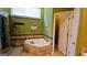 Bathroom with a jetted tub, marble tile, and a view of the backyard at 185 Ridgewood Dr, Fayetteville, GA 30215