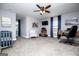 A bedroom includes gray walls, carpet floors, a crib, a ceiling fan and a desk at 640 Lovell Rd, Temple, GA 30179