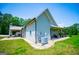 Side view of the home with a covered patio featuring stone columns and a green lawn at 640 Lovell Rd, Temple, GA 30179