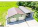 Aerial view of a spacious green garage with two doors and an open carport on a lush green lawn at 640 Lovell Rd, Temple, GA 30179