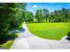 Exterior of a sprawling green property featuring a long gravel driveway leading to a home and detached garage at 640 Lovell Rd, Temple, GA 30179