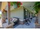 Inviting covered porch featuring stone pillars, outdoor furniture, and decorative hanging plants at 640 Lovell Rd, Temple, GA 30179