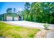Spacious garage with an open carport, complemented by a large concrete driveway and landscaping at 640 Lovell Rd, Temple, GA 30179
