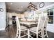 A cozy kitchen with white cabinets, wooden floors, modern lighting, and an island that doubles as a dining area at 640 Lovell Rd, Temple, GA 30179