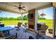 Comfortable covered patio featuring a stone fireplace, ceiling fan, and outdoor seating overlooking lush greenery at 640 Lovell Rd, Temple, GA 30179