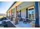 Comfortable covered porch with stone accents, outdoor seating, and beautiful surroundings at 640 Lovell Rd, Temple, GA 30179