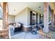Inviting covered porch with stone accents and comfortable seating arrangement at 640 Lovell Rd, Temple, GA 30179