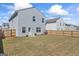 Large backyard with wooden fence, lush green grass, and home exterior view at 813 Royal Red Ct, Mcdonough, GA 30253