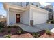 Close-up of a charming entryway features a front door with wreath, landscaped garden and two-car garage at 813 Royal Red Ct, Mcdonough, GA 30253