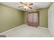 Bedroom with green walls, neutral carpet, and a ceiling fan with light at 346 Buckingham Sw Dr, Conyers, GA 30094