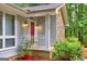 Close-up of the entryway with its red door, white picket fence, and brick base, framed by lush greenery at 346 Buckingham Sw Dr, Conyers, GA 30094