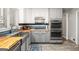 Updated kitchen with stainless steel appliances, butcher block countertops, and stylish gray and white cabinetry at 346 Buckingham Sw Dr, Conyers, GA 30094