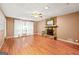 Open living space with hardwood floors, a stone fireplace, and large windows dressed with white curtains at 346 Buckingham Sw Dr, Conyers, GA 30094