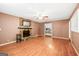 Bright living room showcasing a stone fireplace, hardwood floors, and an open view into the adjacent kitchen at 346 Buckingham Sw Dr, Conyers, GA 30094