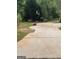 Long driveway leading to a basketball hoop, outbuilding, and mower in a private setting at 329 Harris Ave, Locust Grove, GA 30248