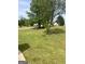 Beautiful, serene front yard with mature trees on a sunny day at 329 Harris Ave, Locust Grove, GA 30248