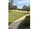 Long yard views with a lush lawn and a sidewalk leading up to the property at 329 Harris Ave, Locust Grove, GA 30248