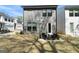 The backyard shows a modern home with a small seating area and grass at 807 Stickley Oak Way, Woodstock, GA 30189
