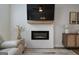 Modern fireplace with a wooden mantle and a flat-screen TV above, flanked by stylish decor at 807 Stickley Oak Way, Woodstock, GA 30189