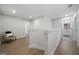 Bright upstairs hallway with light walls, wood-look flooring, chair, and doorway to a bathroom with modern fixtures at 807 Stickley Oak Way, Woodstock, GA 30189