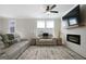 Comfortable living room featuring modern sofas, a ceiling fan, and a cozy fireplace at 807 Stickley Oak Way, Woodstock, GA 30189