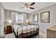 Cozy bedroom featuring a wrought iron bed frame, neutral decor, and an abundance of natural light from the window at 147 Kripple Kreek Dr, Sharpsburg, GA 30277