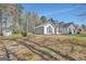 Back exterior view showing the roof line, windows, landscaping, shed, and a portion of the grassy backyard at 147 Kripple Kreek Dr, Sharpsburg, GA 30277