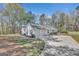 This property features a three-car garage and a long driveway with a serene, wooded backdrop at 147 Kripple Kreek Dr, Sharpsburg, GA 30277