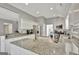 Well-lit kitchen with white cabinets, granite countertops, and a central island at 147 Kripple Kreek Dr, Sharpsburg, GA 30277