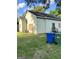 Exterior backyard view featuring a light green house, trash bins, and a partially fenced yard at 466 Joseph E Lowery Nw Blvd, Atlanta, GA 30314