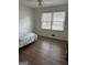 A cozy bedroom with hardwood floors and natural light from a large window at 2791 Biscayne Dr, Conyers, GA 30012