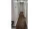 Hallway with hardwood floors and neutral walls, with doors leading to various rooms at 2791 Biscayne Dr, Conyers, GA 30012