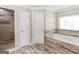 Well-lit bathroom featuring a soaking tub, tiled floors and a glass door shower at 200 Magnolia Ct, Mcdonough, GA 30252