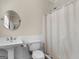 Clean and crisp bathroom featuring a pedestal sink, toilet, and shower with curtain at 200 Magnolia Ct, Mcdonough, GA 30252