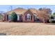 Charming brick home featuring a lawn of dry dormant grass and appealing landscaping at 200 Magnolia Ct, Mcdonough, GA 30252