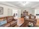 Bright living room with hardwood floors, leather sofas, and large windows, perfect for relaxation and entertaining at 200 Magnolia Ct, Mcdonough, GA 30252