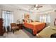 Bright bedroom with tray ceiling and a cozy seating area, with an orange bedspread at 100 Williams Blf, Mcdonough, GA 30252