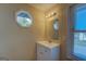 Bright bathroom with vanity cabinet, framed mirror, unique octagonal window and recessed lighting at 34 Ivy St, Porterdale, GA 30014