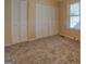 Bedroom featuring carpeted floors, a window, and a closet with folding doors at 34 Ivy St, Porterdale, GA 30014