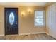 Inviting entryway featuring light wood-look flooring, tan walls, and a decorative glass front door at 34 Ivy St, Porterdale, GA 30014